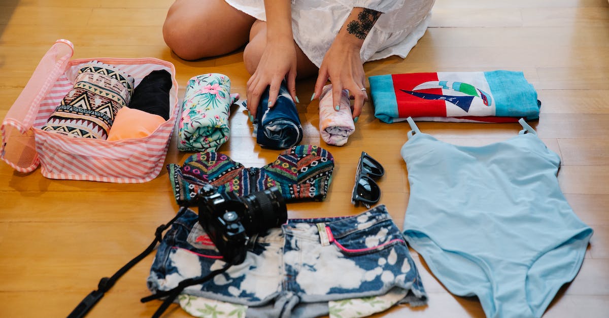 a-person-sitting-on-a-wooden-floor-while-preparing-travel-essentials