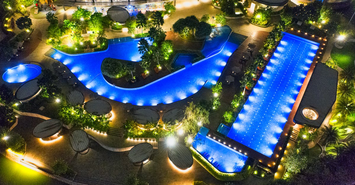 aerial-photo-of-illuminated-outdoor-swimming-pools-in-various-shapes-at-night