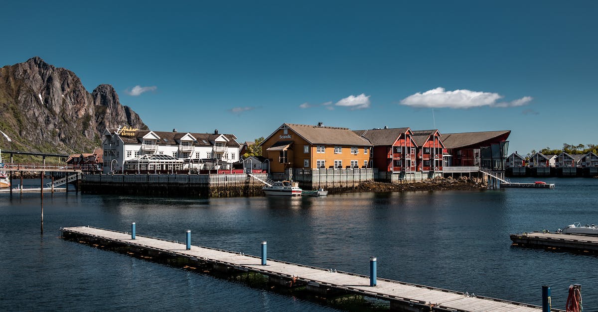 brown-wooden-dock-on-river-near-houses-under-blue-sky-1