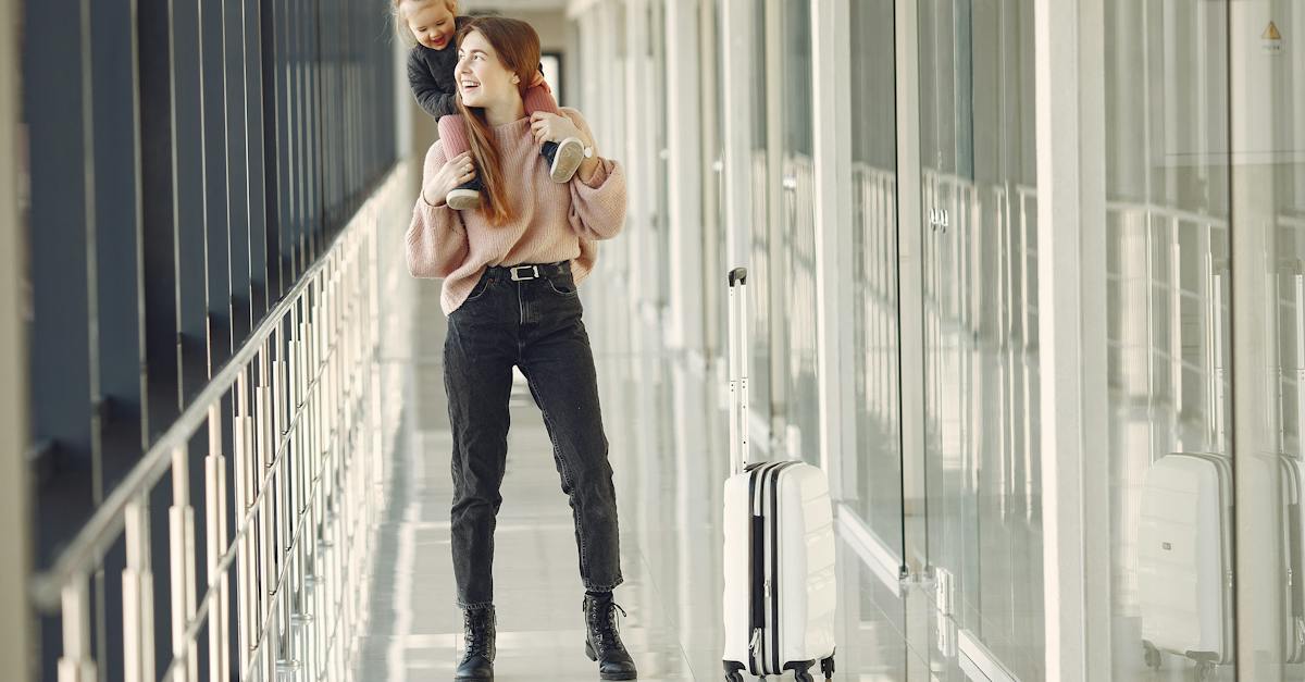 cheerful-woman-with-daughter-and-suitcase-in-airport-2