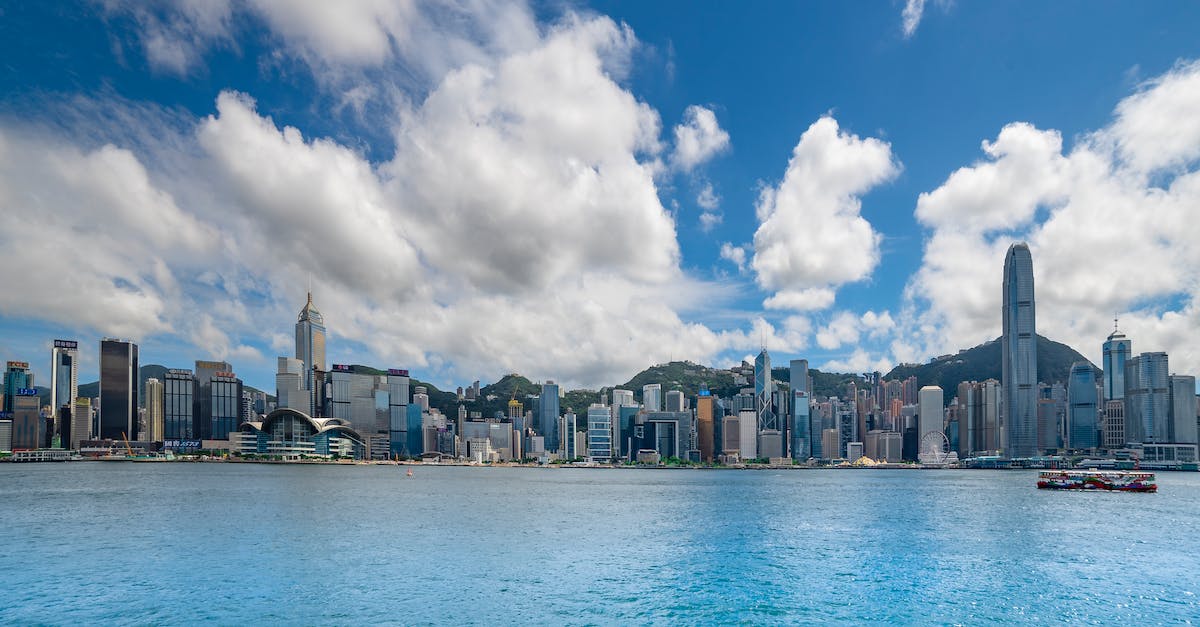 city-buildings-near-body-of-water-under-blue-sky-and-white-clouds