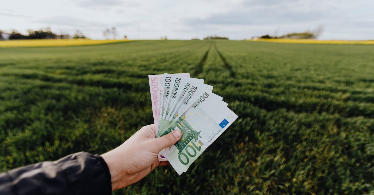 crop-farmer-showing-money-in-green-summer-field-in-countryside