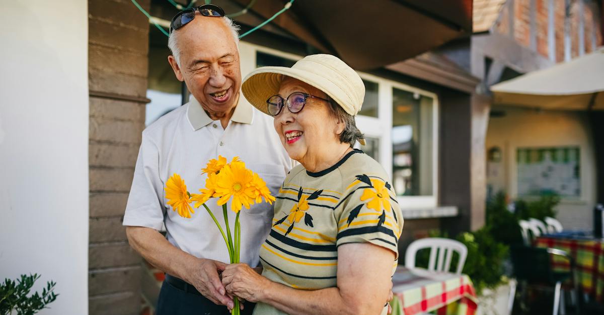 elderly-couple-holding-bouquet-of-flowers-while-holding-hands