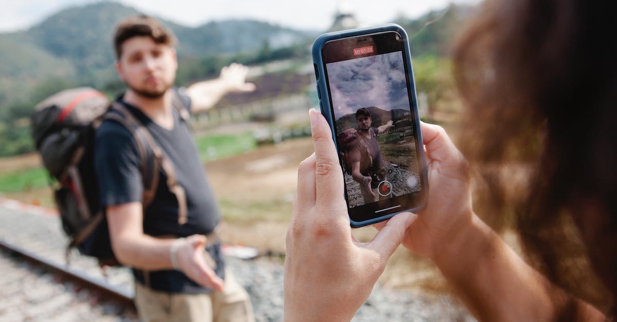 female-taking-video-of-traveler-during-hike-in-countryside-in-daylight