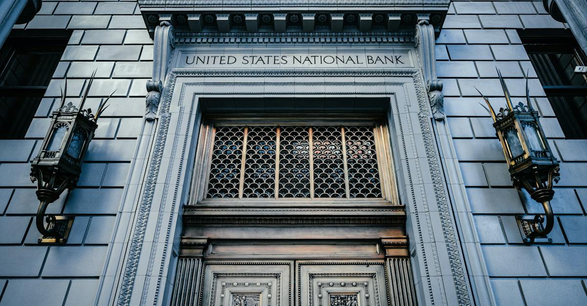 from-below-classic-styled-historic-building-of-united-states-national-bank-with-wooden-doors-and-vin