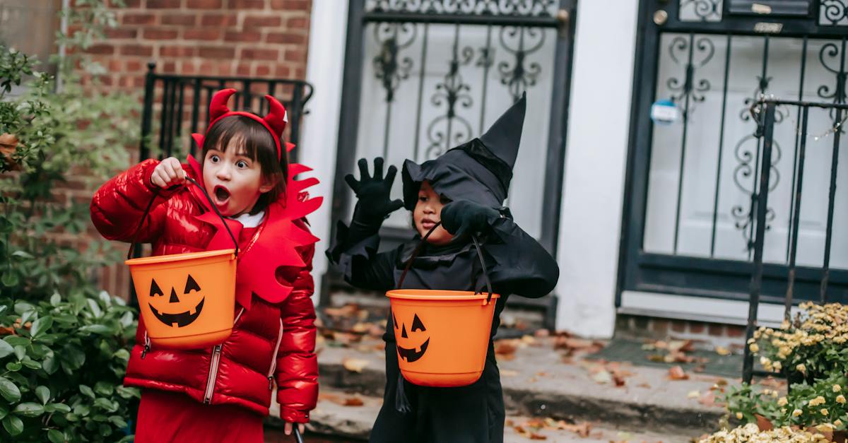 funny-children-in-witch-and-devil-costumes-carrying-buckets-for-candies-and-showing-creepy-grimaces