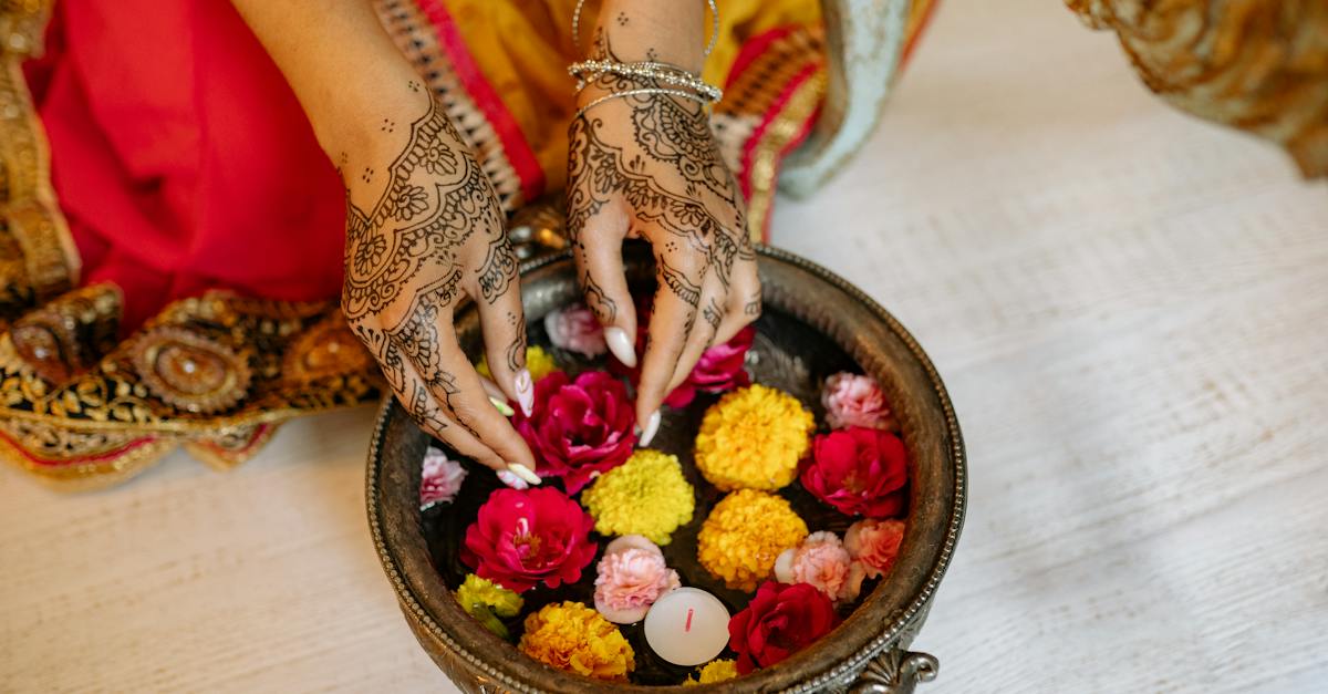 hands-with-mehndi-putting-the-colorful-flowers-on-the-water-2