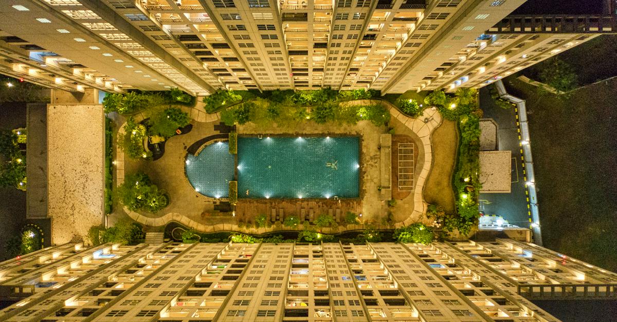 high-angle-photography-of-rectangular-green-swimming-pool-in-between-high-rise-buildings