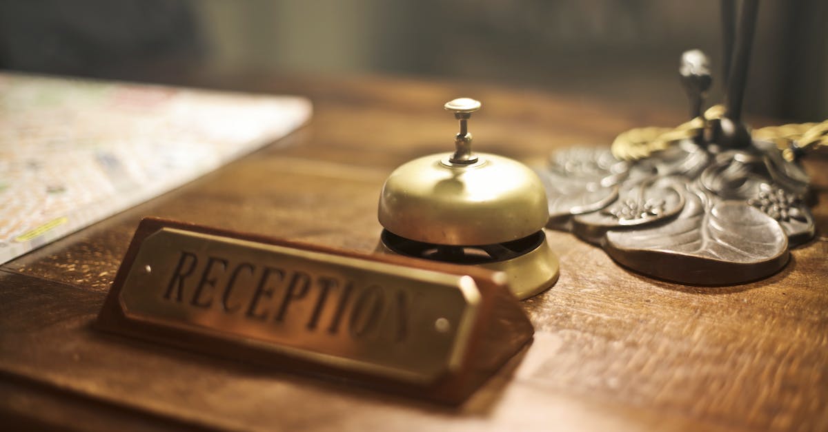 old-fashioned-golden-service-bell-and-reception-sign-placed-on-wooden-counter-of-hotel-with-retro-in-2