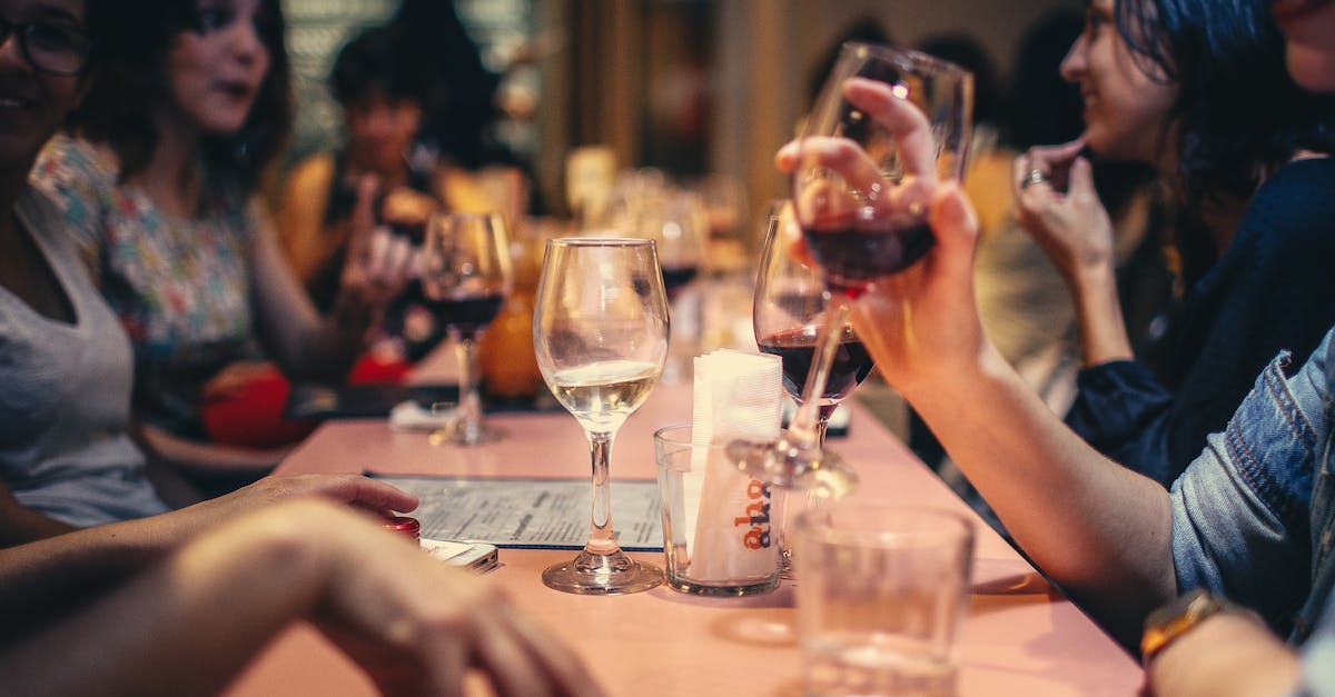 people-drinking-liquor-and-talking-on-dining-table-close-up-photo