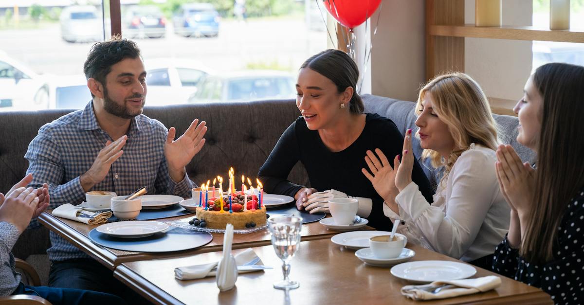 people-sitting-at-table-with-birthday-cake