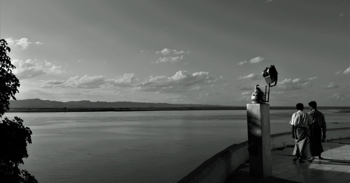 person-standing-on-wooden-dock-in-grayscale-photography