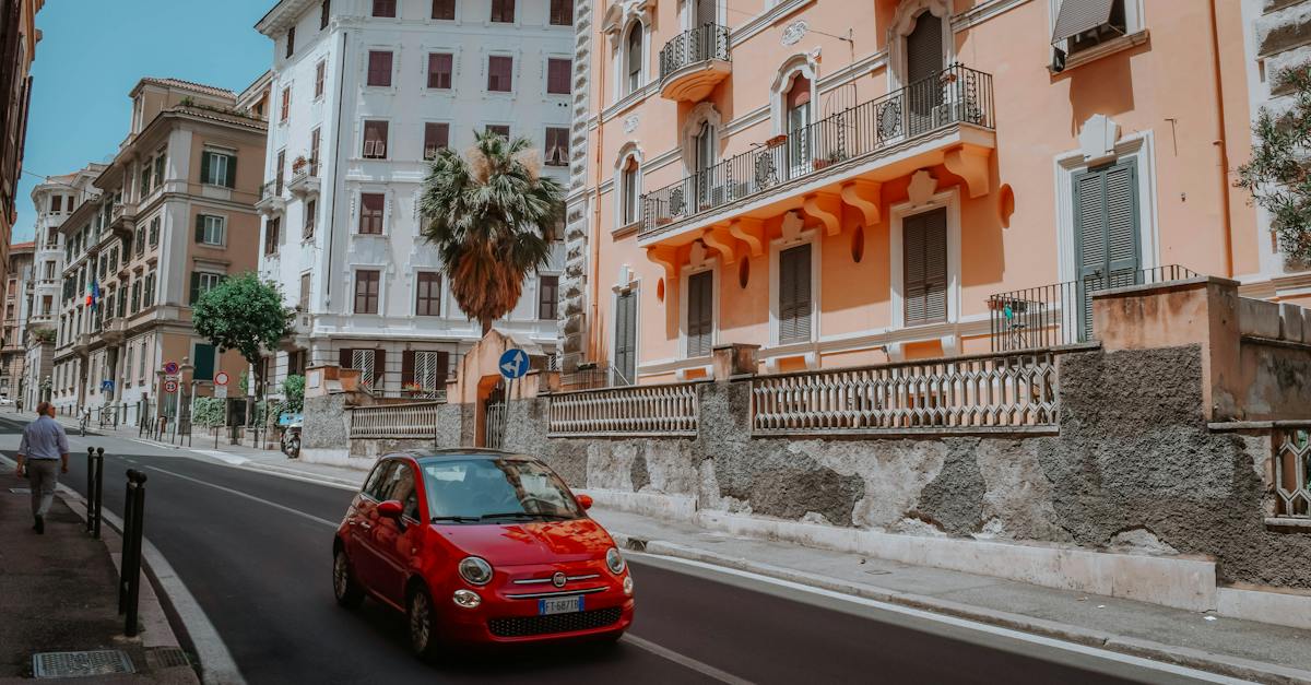 red-5-door-hatchback-on-a-narrow-street-lined-with-apartment-buildings-1
