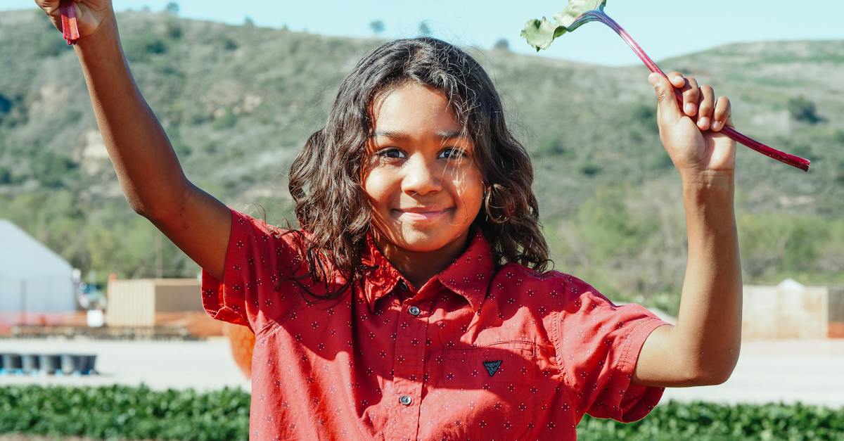 smiling-black-girl-with-beet-leaf-on-plantation