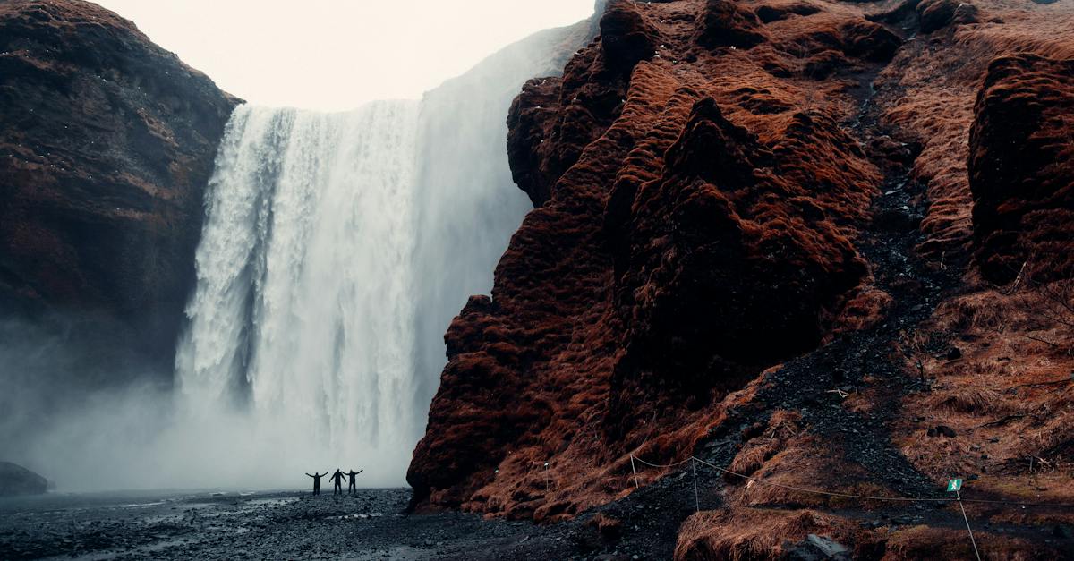 three-men-standing-near-waterfalls
