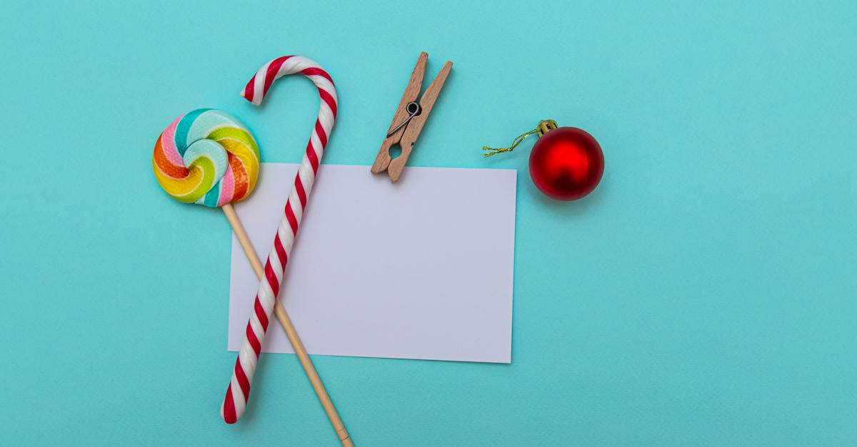 top-view-layout-of-striped-candy-cane-and-colorful-lollipop-composed-with-red-christmas-bauble-and-w
