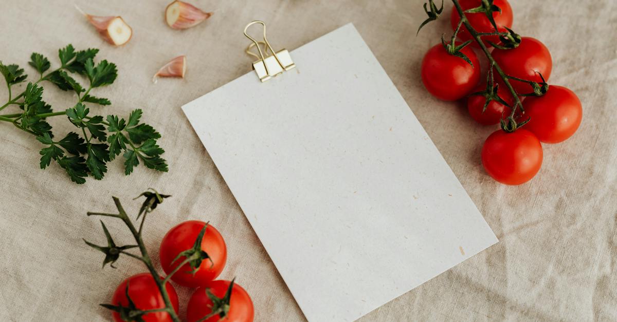 top-view-of-blank-clipboard-with-golden-paper-binder-placed-on-linen-tablecloth-among-tasty-red-toma-2