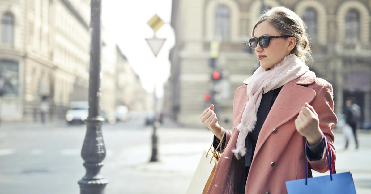 woman-in-pink-coat-holding-shopping-bags