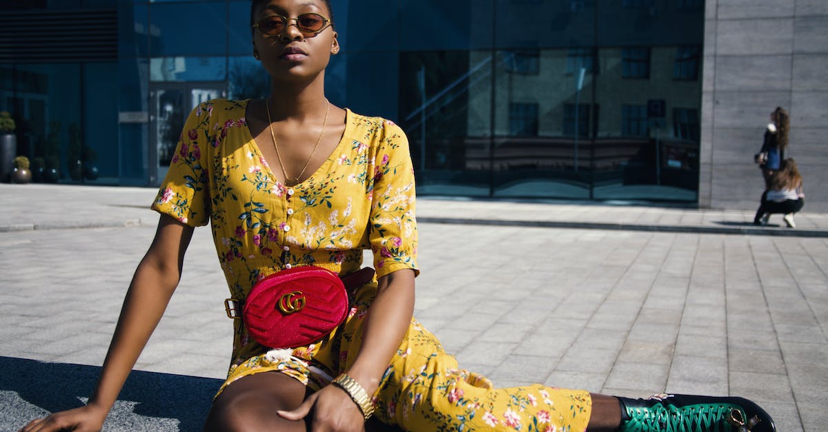 woman-in-yellow-floral-jumpsuit-sitting-on-concrete-floor