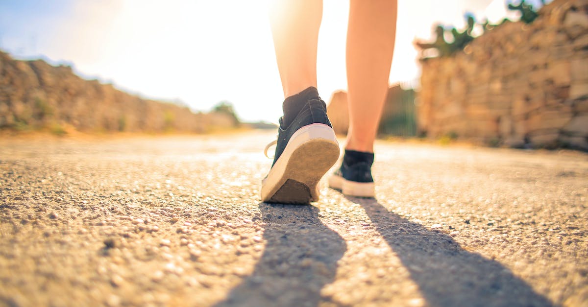 woman-walking-on-pathway-under-the-sun