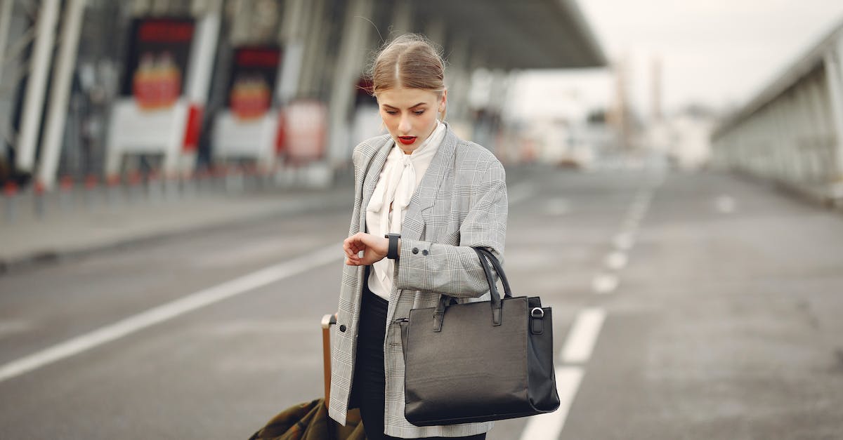 worried-young-businesswoman-with-suitcase-hurrying-on-flight-on-urban-background-1