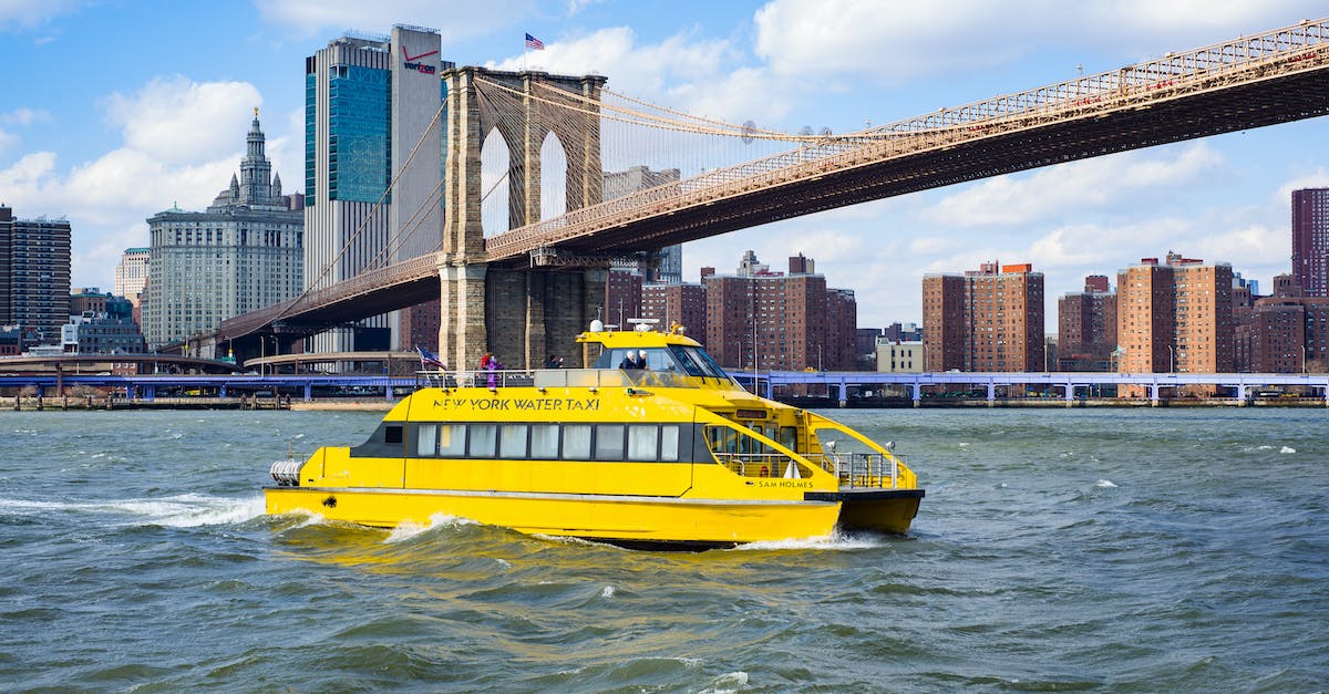 yellow-vessel-boat-sailing-on-river-near-bridge